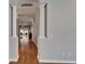 Hallway with wood floors, white trim, and neutral paint at 11626 Pure Pebble Dr, Riverview, FL 33569