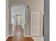 Hallway with wood floors, white trim, and arched doorway at 11626 Pure Pebble Dr, Riverview, FL 33569