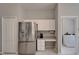 Kitchen with stainless steel refrigerator, desk area, and laundry room access at 11626 Pure Pebble Dr, Riverview, FL 33569