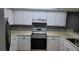 Well-lit kitchen featuring stainless steel appliances, white cabinets, and ample countertop space at 12041 Environmental Dr # 6, New Port Richey, FL 34654