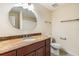 Traditional bathroom featuring a granite countertop, wood vanity, and large mirror at 12233 Armenia Gables Cir # 12233, Tampa, FL 33612