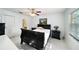 Main bedroom features ensuite bath, ceiling fan, bright windows, and black bedroom furniture at 1349 Foxboro Dr, Brandon, FL 33511