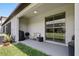Covered back patio features a grill and sliding glass doors to the home and manicured lawn at 14323 Easy Goer St, Ruskin, FL 33573