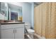 Light and airy bathroom with a modern vanity, granite countertop, and shower with patterned curtain at 14323 Easy Goer St, Ruskin, FL 33573