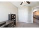 Neutral bedroom featuring gray carpet, ceiling fan, and storage shelves next to a closet at 14323 Easy Goer St, Ruskin, FL 33573