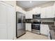 Well-equipped kitchen with white cabinets and stainless steel appliances at 14323 Easy Goer St, Ruskin, FL 33573