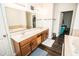 Bathroom vanity with double sinks, wood cabinets and large mirrors, view to soaking tub at 1510 Rushgrove Cir, Dover, FL 33527