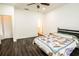 Large bedroom with dark floors, a ceiling fan, and a bed with a patterned quilt at 1510 Rushgrove Cir, Dover, FL 33527