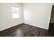 Bedroom featuring dark floors, a large window, and a view of an ensuite at 1510 Rushgrove Cir, Dover, FL 33527