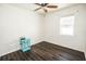 Bedroom with dark floors, ceiling fan, window, and table at 1510 Rushgrove Cir, Dover, FL 33527