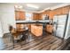 Open concept kitchen with oak cabinets, stainless appliances, black countertops and dining area at 1510 Rushgrove Cir, Dover, FL 33527