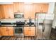 Kitchen features stainless steel appliances, a black countertop, and oak cabinets at 1510 Rushgrove Cir, Dover, FL 33527