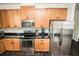 Well-equipped kitchen boasts granite countertops, stainless steel appliances, and wooden cabinets at 1510 Rushgrove Cir, Dover, FL 33527