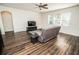 Spacious living room featuring wood floors, a ceiling fan and comfortable seating at 1510 Rushgrove Cir, Dover, FL 33527