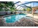 A screened-in pool and spa is surrounded by pavers and landscaping at 1510 Rushgrove Cir, Dover, FL 33527
