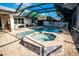Backyard view of screened-in pool with a spa, surrounding pavers and patio area at 1510 Rushgrove Cir, Dover, FL 33527