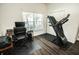 Dedicated workout space with a treadmill and wood-look flooring near a large window at 1510 Rushgrove Cir, Dover, FL 33527