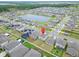 An aerial view of a modern home surrounded by manicured lawns in a Gathering-friendly neighborhood with a community pond at 16685 Parker River St, Wimauma, FL 33598