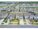 Aerial community view featuring homes, landscaping, driveways, and street layout near a lake at 16685 Parker River St, Wimauma, FL 33598