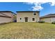 Well-kept backyard featuring a grassy lawn and the home's exterior at 16685 Parker River St, Wimauma, FL 33598