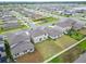 Aerial view of the backyard of a modern home, featuring a spacious lawn and AC units on the side of the house at 16685 Parker River St, Wimauma, FL 33598