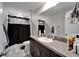 Well-lit bathroom with dark vanity, shower with curtain, and ample counter space at 16685 Parker River St, Wimauma, FL 33598