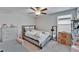 Well-lit bedroom features a full bed, ceiling fan, and natural light from the nearby window at 16685 Parker River St, Wimauma, FL 33598