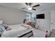 Comfortable bedroom with ceiling fan, TV, shelving, and a large window that brings in light at 16685 Parker River St, Wimauma, FL 33598