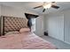 Bedroom features tufted headboard, ceiling fan, and double door closet at 16685 Parker River St, Wimauma, FL 33598