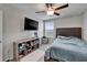 Bedroom showcasing a ceiling fan, large television, and a window at 16685 Parker River St, Wimauma, FL 33598