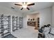 Bedroom featuring a ceiling fan, decorative shelving, and view into the hallway at 16685 Parker River St, Wimauma, FL 33598