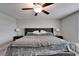 This bedroom features a plush bed, ceiling fan, and bedside tables at 16685 Parker River St, Wimauma, FL 33598