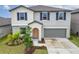 Beautiful two-story home with blue shutters, a two-car garage, and landscaped front yard at 16685 Parker River St, Wimauma, FL 33598
