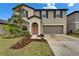 Inviting two-story home features a tidy front yard, cozy entrance, and convenient two-car garage at 16685 Parker River St, Wimauma, FL 33598