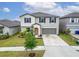 Two-story home with a two-car garage, manicured lawn, and charming front yard landscaping at 16685 Parker River St, Wimauma, FL 33598