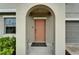 Inviting front door with an arched entryway, enhanced by lush greenery at 16685 Parker River St, Wimauma, FL 33598