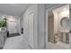 Hallway with tile flooring, a closet, view of powder room, and entry door at 16685 Parker River St, Wimauma, FL 33598