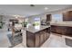 Spacious kitchen area with dark cabinetry, granite countertops, and an island looking into the living room at 16685 Parker River St, Wimauma, FL 33598