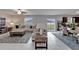 Living room featuring tile flooring, plush seating, and sliding glass doors to the backyard at 16685 Parker River St, Wimauma, FL 33598