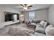 Comfortable living room features a plush gray sectional sofa and a large wall-mounted television at 16685 Parker River St, Wimauma, FL 33598
