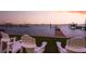 Backyard view featuring lush lawn, waterfront access, and city views with chairs to relax and enjoy at 1748 Sunset Dr, Clearwater, FL 33755