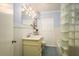 A blue and white bathroom with glass block shower, beadboard, and a vintage vanity at 1748 Sunset Dr, Clearwater, FL 33755