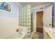 Bathroom featuring a glass block partition, blue accent wall, and a vintage-style vanity at 1748 Sunset Dr, Clearwater, FL 33755