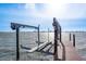 Boat lift at end of wooden dock extends into the water with city skyline views at 1748 Sunset Dr, Clearwater, FL 33755