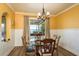 Bright dining room with backyard and water view, stylish chandelier, and hardwood floors at 1748 Sunset Dr, Clearwater, FL 33755