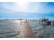 Long wooden dock with boat lift extending into the water with city skyline views at 1748 Sunset Dr, Clearwater, FL 33755