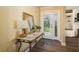 Bright entryway featuring a decorative glass door, marble topped table and a large mirror at 1748 Sunset Dr, Clearwater, FL 33755