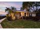 Well-lit exterior showcases a charming single-story home with lush landscaping and nighttime appeal at 1748 Sunset Dr, Clearwater, FL 33755