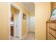 A hallway with tile floors and yellow walls and a glimpse into a kitchen area through an arched doorway at 1748 Sunset Dr, Clearwater, FL 33755