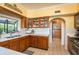 A kitchen with tile floors, countertops, wooden cabinets and drawers, stainless steel sink and view of purple flowers outside at 1748 Sunset Dr, Clearwater, FL 33755